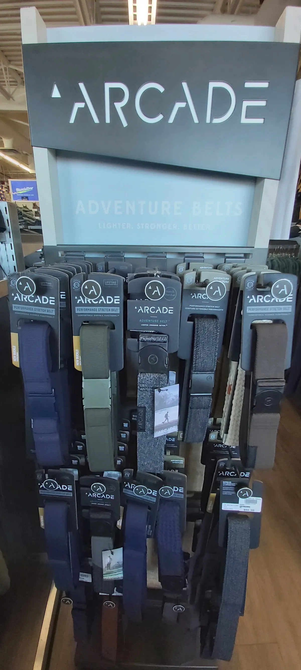 An Arcade Adventure Belts spinner rack of stretch webbing belts