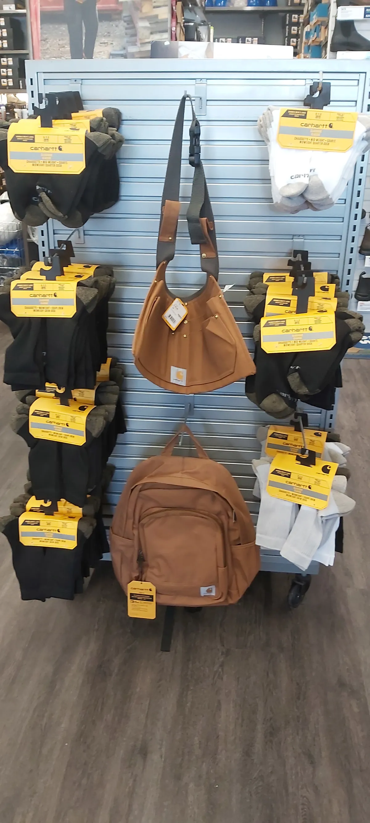 Bags and a backpack hung on a slatwall with clearance tags