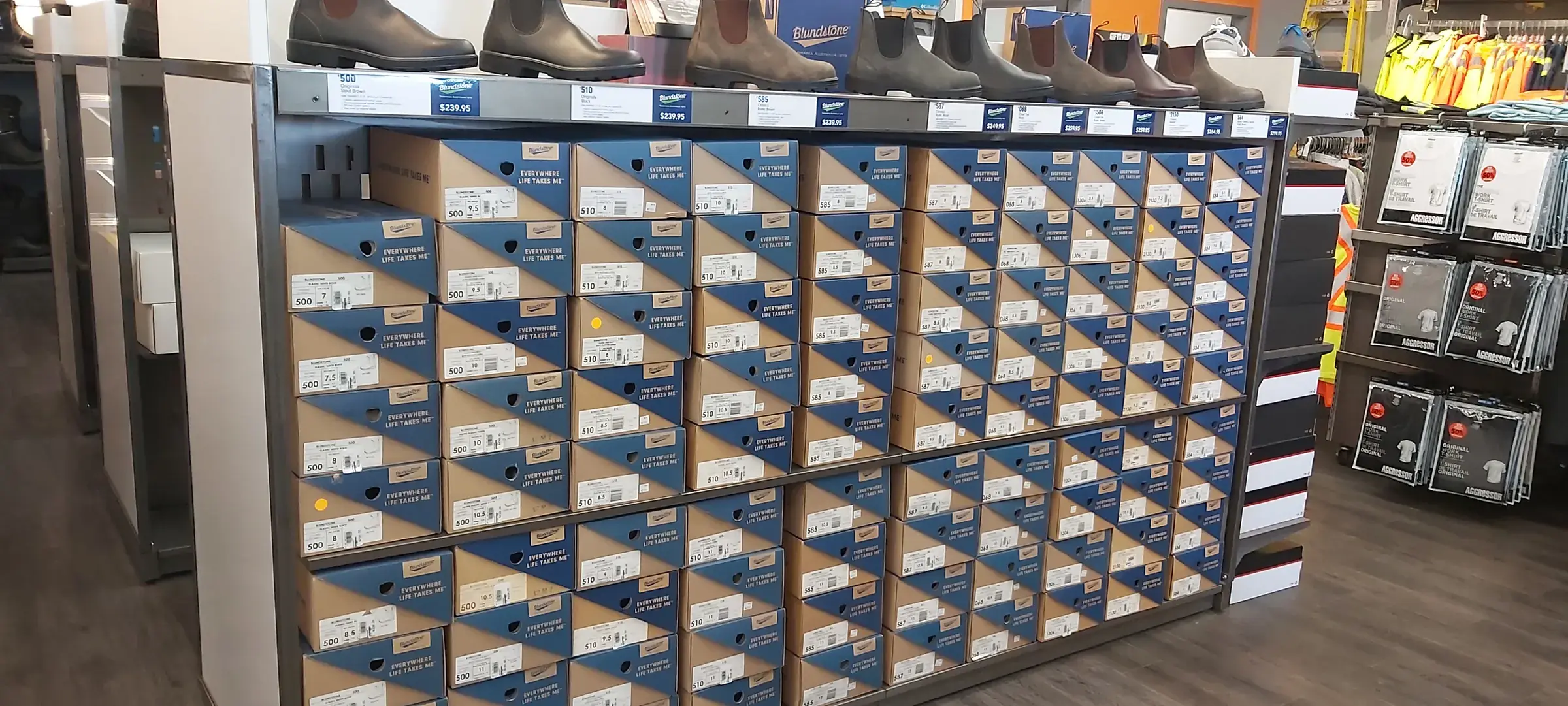 A wall of Blundstone stock boxes with boots displayed along the top shelf