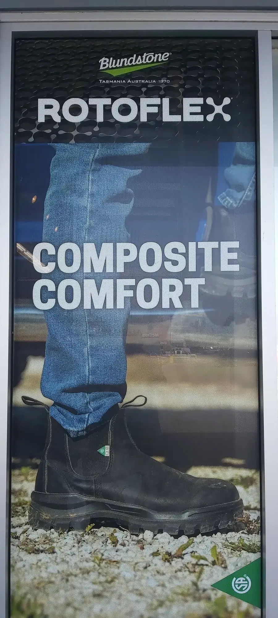 A Blundstone Rotoflex window poster reading "Composite Comfort", showing a black work boot