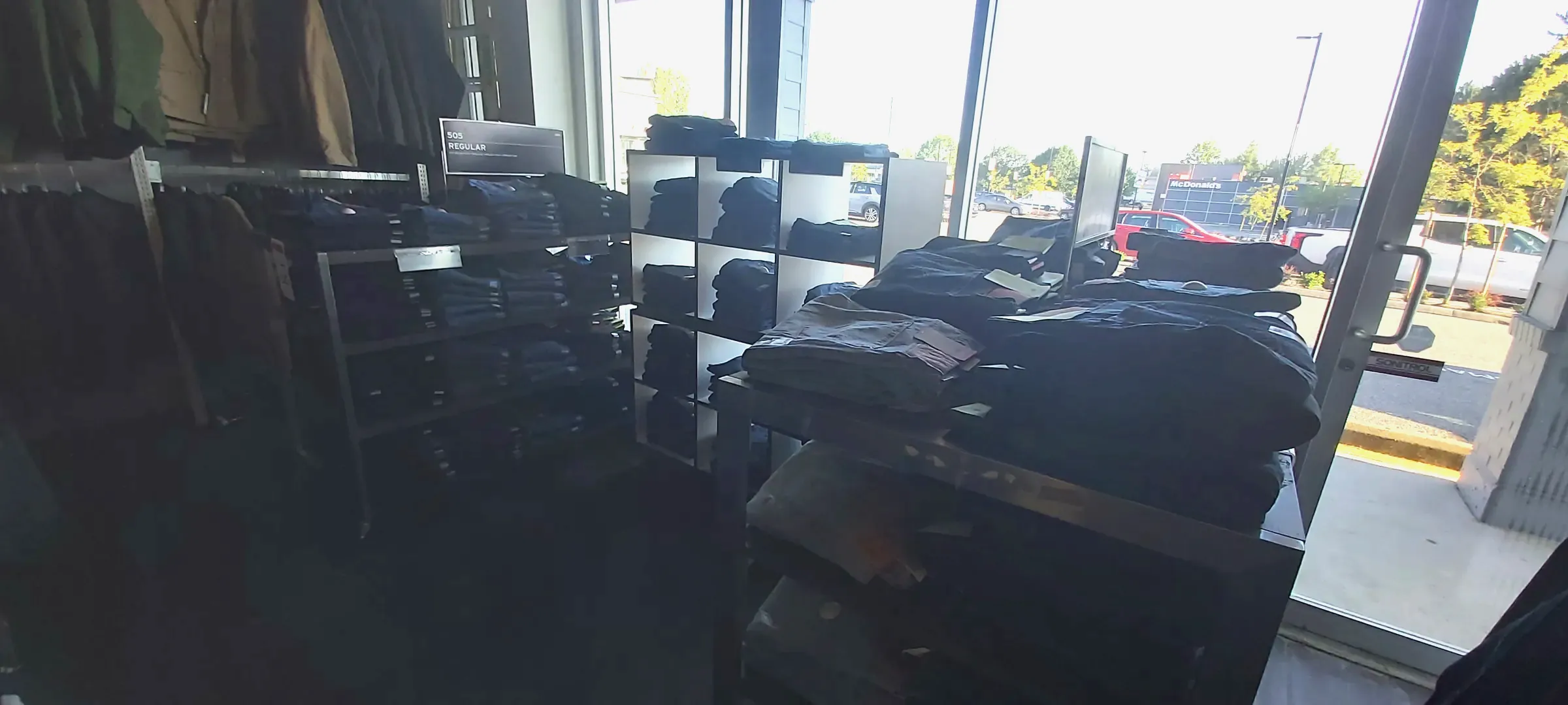 The denim floor with hung and folded stock, daylight from the front windows