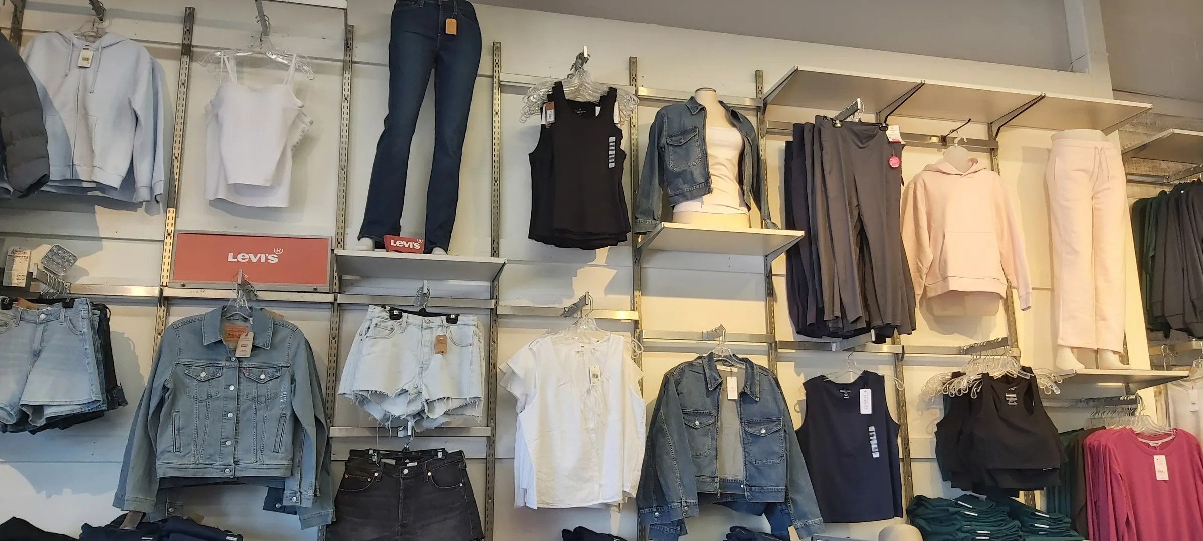 A Levi's women's wall with denim jackets, jeans, shorts and tops on display arms